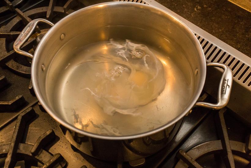 Poached egg in pot of water