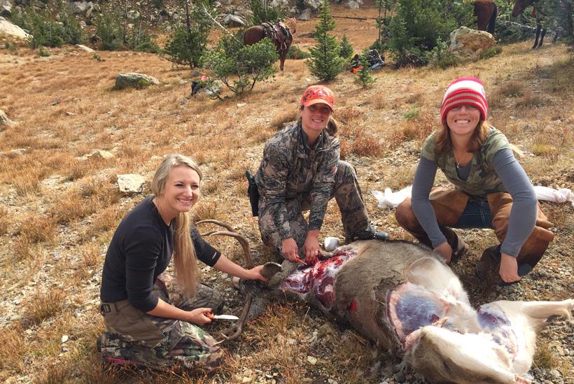 All of the girls cutting up a mule deer buck