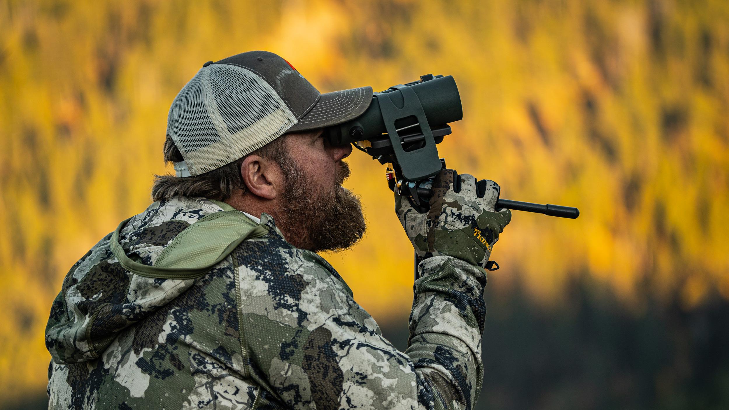 Brandon Evans glassing with binoculars mounted on a tripod