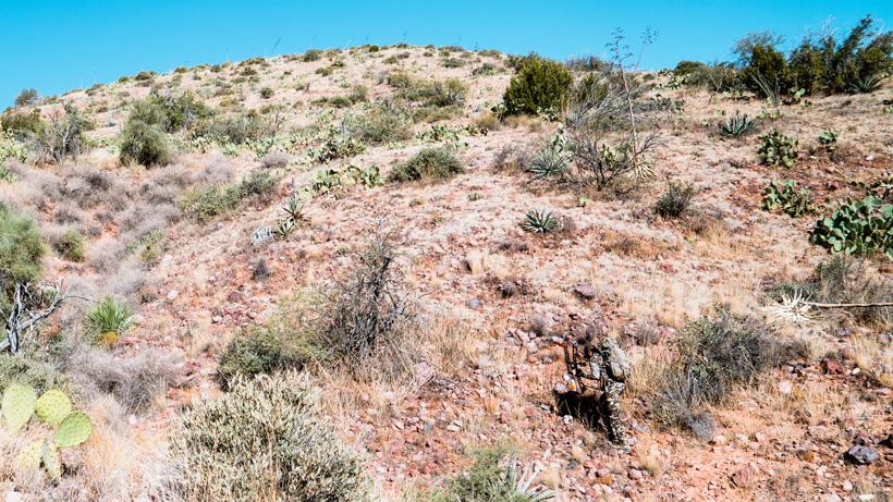 Bowhunter scaling mountain