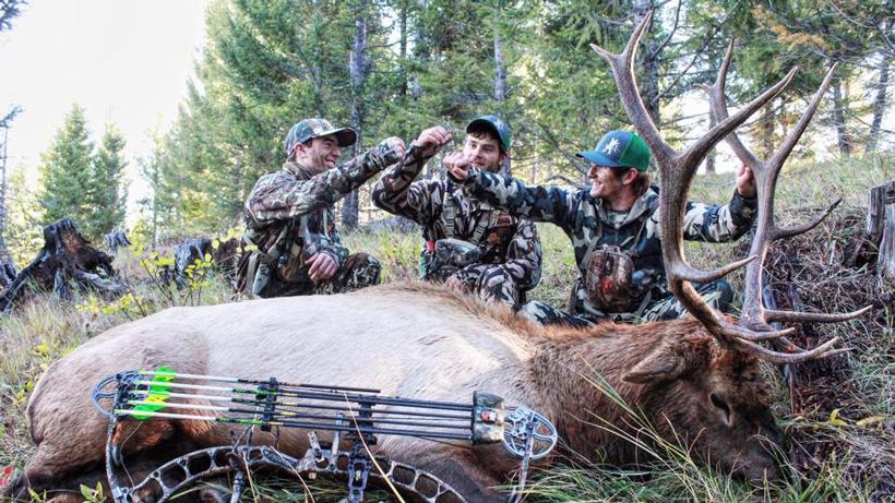 Friends fist pounding after successful elk hunt