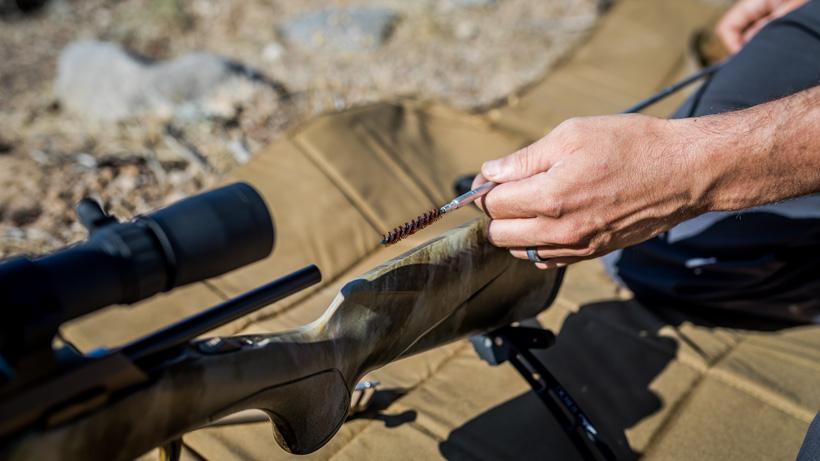 Cleaning the rifle barrel again with a brush